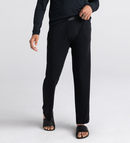 Man wearing black sleep pants and long sleeve tee with black slippers